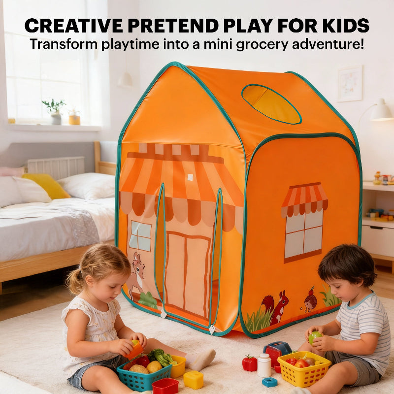 Two toddlers sitting on a rug in a bedroom, playing with plastic toy food and baskets in front of the grocery play tent