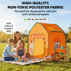 A mother and two children playing with a toy market stall and grocery items on a picnic blanket next to an orange play tent in a park; includes a "CPC & Lab Tested" badge.