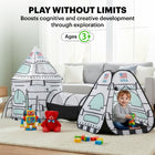 Toddler playing with colorful blocks inside a rocket ship play tent in a bright indoor living room setting.